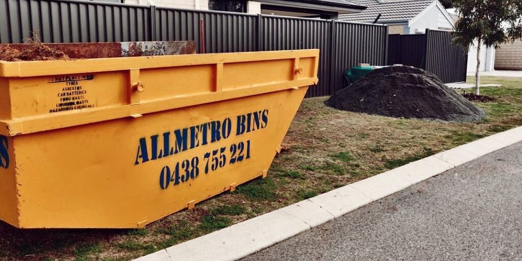 A yellow Perth skip bin outside a residential property.