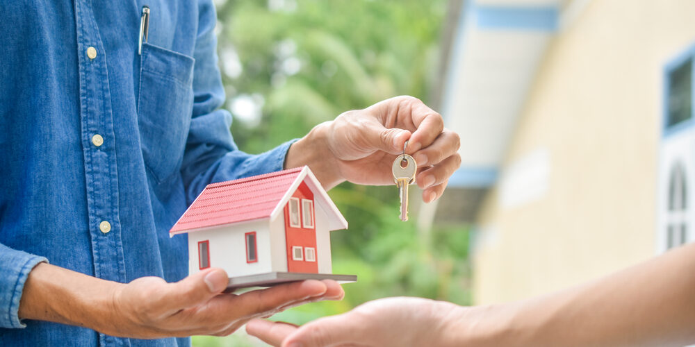 Salesman giving key house for customer rent buy real estate business investment, Hand holding key and home model